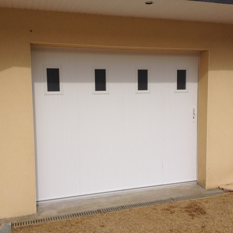 Porte de garage coulissante en PVC 4 panneaux et hublots partie haute teinte blanche
